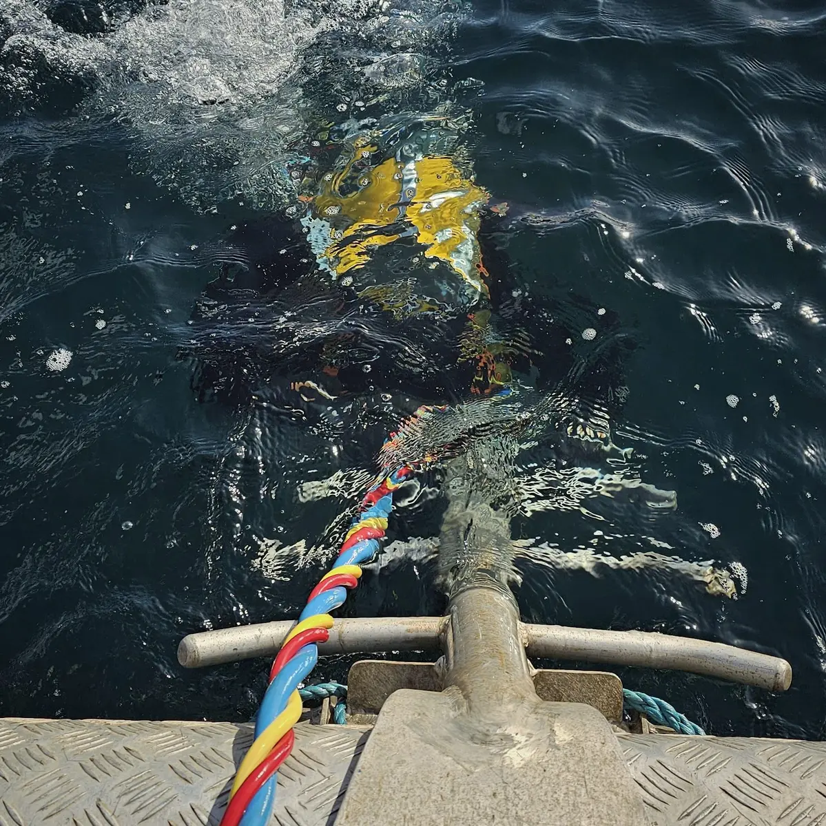 Surface-supplied commercial diver entering the water with an umbilical